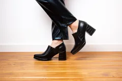 Botines negros de cuero con plataforma y taco cuadrado con textura de reptil.