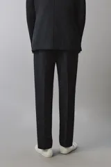Pantalón de traje regular fit negro, confeccionado en tejido técnico transpirable Non Iron, con bolsillos frontales, bolsillos traseros de vivo y cierre frontal con cremallera y botón.