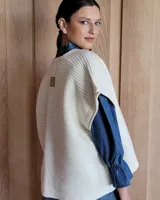 Chaleco tejido de punto color lila, sin mangas y con cuello abierto.