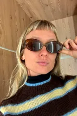 Sweater de tejido de punto con diseño a rayas horizontales en tonos marrón, amarillo y celeste. Presenta cuello redondo, mangas largas con puños acanalados y una silueta relajada.