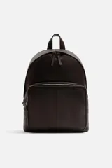 Mochila marrón oscuro de cuero, con compartimento principal con cierre de cremallera, bolsillo interno plano y bolsillo interno con cremallera. Bolsillo frontal con cremallera, parte posterior acolchada con banda de sujeción para equipaje, asa de mano y dos asas de hombro ajustables.