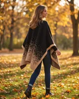 Poncho de tejido de punto en color negro y beige, con diseño degradé de puntos, de corte abierto y fluido.