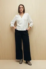 Pantalón wide leg color crudo, de tiro alto, con grandes bolsillos laterales y traseros.