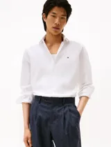 Camisa blanca de popelina de algodón regenerativo, corte slim fit, manga larga, cuello abotonado, cierre con botones y logo de Tommy Hilfiger bordado en el pecho.