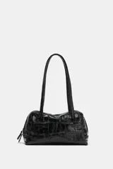 Bolso de hombro negro de formato bowling con textura efecto cocodrilo, doble asa de hombro y cierre con cremallera.