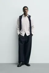 Camisa de corte regular fit confeccionada en tejido de algodón con estampado de cuadros pequeños. Presenta cuello abotonado, manga larga con puños abotonados, bolsillo de plastrón en el pecho y cierre frontal con botones.