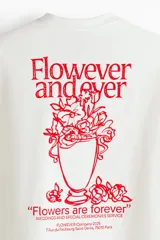 Remera de algodón blanca de corte holgado, con cuello redondo y diseño estampado en el pecho con texto en color rojo.