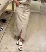 Pollera midi de cuero ovino con diseño tipo jean, cierre frontal con botón y tajo central.