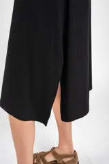 Vestido midi negro de manga corta, confeccionado en tejido de punto acanalado, con cuello redondo y corte recto.