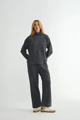Conjunto de dos piezas compuesto por un sweater de cuello alto con aberturas laterales y un pantalón de corte recto, ambos confeccionados en tejido de punto suave.