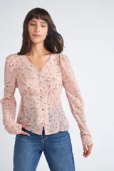 Blusa rosa con estampado de flores blancas y amarillas, cuello en V, manga larga abullonada y cierre frontal con botones.