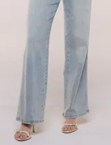 Jean wide leg de tiro medio y corte amplio, color azul claro. Presenta cintura con presillas, acceso frontal mediante cierre y botón metálico, y diseño de cinco bolsillos clásicos.