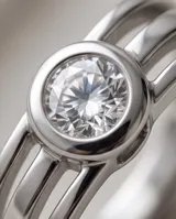 Anillo de acero plateado con circonia central redonda engastada, de diseño delicado y elegante.