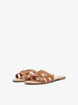 Sandalias planas Only de efecto cuero color marrón, con diseño de tiras cruzadas en el empeine, punta almendra y suela de caucho termoplástico.