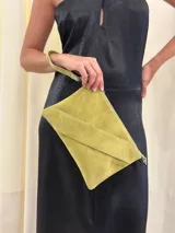 Sobre/cartera de cuero gamuza color verde lima, con diseño plegable y cierre de cremallera. Incluye una correa corta para la muñeca y una correa larga para usar al hombro o como bandolera, ambas desmontables.