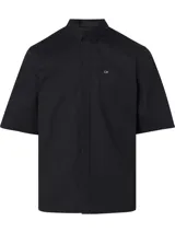 Camisa negra de manga corta con corte boxy, cuello en punta, bolsillo de parche en el pecho y logo CK bordado.