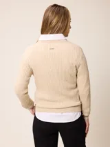 Sweater de punto con diseño de trenzas verticales, color negro, con cuello redondo, mangas largas y puños con detalle en contraste blanco. Presenta un pequeño logo bordado en el pecho.