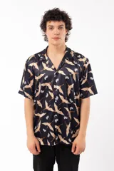 Camisa negra con estampado de grullas y flores, de manga corta y corte relajado, con cuello tipo sastre.