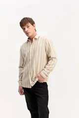 Camisa de manga larga color beige, de tejido texturado con cierre frontal de botones y cuello camisero clásico.