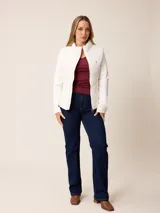 Campera acolchada con frente y espalda en tejido técnico, combinada con mangas y laterales de tejido liso. Presenta cuello alto, cierre frontal completo y bolsillos laterales. Incluye un pequeño detalle bordado en el pecho.