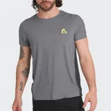 Remera deportiva Le Coq Sportif de corte ajustado, color gris con paneles laterales en gris oscuro y logo de la marca estampado en amarillo en el pecho.