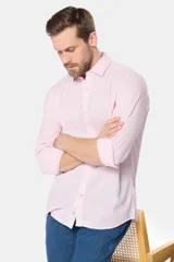 Camisa de lino rayada de manga larga, con cuello camisero, cierre frontal de botones y detalle de logo bordado en el pecho.