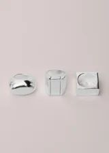 Anillo plateado de diseño geométrico cuadrado, fabricado en aleación de zinc con acabado brillante.