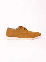 Zapato acordonado de estilo casual con capellada de material sintético efecto gamuza en color tostado, cordones al tono y suela plana de goma en color blanco.