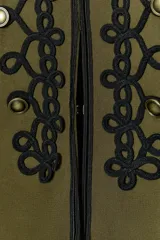 Blazer de estilo militar confeccionado en algodón, con cuello subido y manga larga. Presenta un diseño estructurado con detalle de alamares negros a contraste en el frente, botones metálicos decorativos y trabillas laterales. Cuenta con cierre frontal oculto y forro interior.