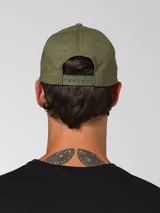 Gorra con visera curva de color verde militar, con el logotipo de Caterpillar bordado en relieve en la parte delantera.