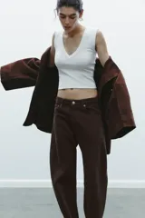 Camiseta negra de corte ajustado (slim fit) con escote en pico profundo y manga sisa.