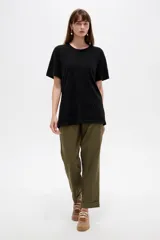Remera de algodón negra, de manga corta, corte holgado y cuello redondo a la base.