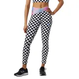 Calza deportiva New Balance con estampado a cuadros blancos y negros, cintura alta cruzada con diseño iridiscente y logo de la marca en la pierna.