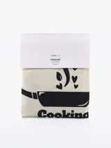 Delantal color natural con estampado de una olla y la frase "Cooking is Love".