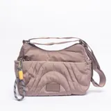 Bandolera de diseño acolchado con costuras curvas, color caqui. Cuenta con correa ajustable, cierre principal y un detalle de llavero de cuerda con mosquetón en el lateral.