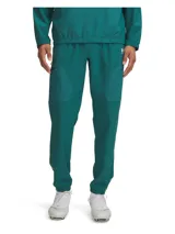 Pantalón deportivo de calentamiento Under Armour color verde oscuro, de corte recto con cintura elástica, bolsillos laterales con cierre y puños elásticos.