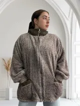 Campera marrón de tela tipo teddy con cierre frontal, cuello alto y bolsillos laterales.