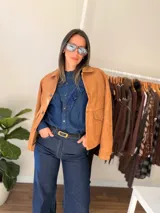 Chaqueta de estilo clásico con acabado efecto gamuza, confeccionada en algodón. Presenta cierre frontal con botones, cuello camisero y dos bolsillos delanteros con solapa. Posee interior forrado y corte recto.