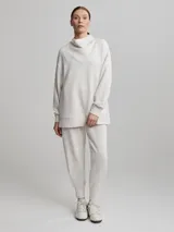 Sweater jogger largo color crema con cuello tortuga.