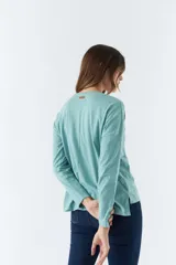 Remera de manga larga color verde agua con estampado frontal y logo en grifa de cuero.