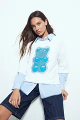 Remerón de corte oversize y silueta relajada, con estampa gráfica frontal de un oso de goma en tonos azules. Presenta un acabado con proceso de lavado que le otorga un efecto desgastado.