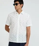 Camisa blanca de algodón con bordado de flores, corte regular, cuello inglés, manga corta y abotonadura frontal.