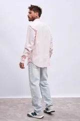 Camisa de manga larga color rosa claro con botones. Corte clásico.