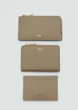 Billetera pequeña de mujer marca Mango, con acabado efecto saffiano en color beige. Cuenta con cierre de botón a presión, múltiples ranuras para tarjetas y un bolsillo exterior con cierre de cremallera. Incluye logo de la marca en relieve en la parte frontal.