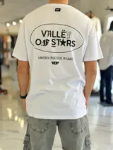 Remera blanca oversize con estampado gráfico en la espalda con la inscripción "Valley of Stars", diseño de manga corta y corte holgado.