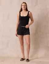 Conjunto de pijama de dos piezas marca René Rofé, compuesto por un top blanco de breteles finos y un short gris con rayas horizontales blancas, cintura elastizada y cordón de ajuste.