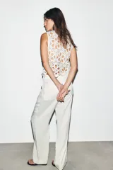 Pantalón de tiro medio con corte recto, cintura elástica con cordón ajustable, bolsillos delanteros y bolsillos de plastrón en la parte trasera.
