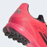 Championes Adidas F50 League para césped sintético, color rosa vibrante con las tres franjas negras. Presentan un diseño ligero con parte superior Fiberskin, estampado Sprintgrid en el antepié y lengüeta elástica.