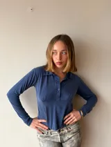Top de lycra estilo chomba color azul, de manga larga y ajuste entallado con cierre frontal de botones y cuello polo.