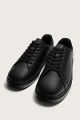 Zapatilla urbana monocolor blanca con cordones al tono, diseño de parte superior lisa, puntera redondeada y suela con volumen.